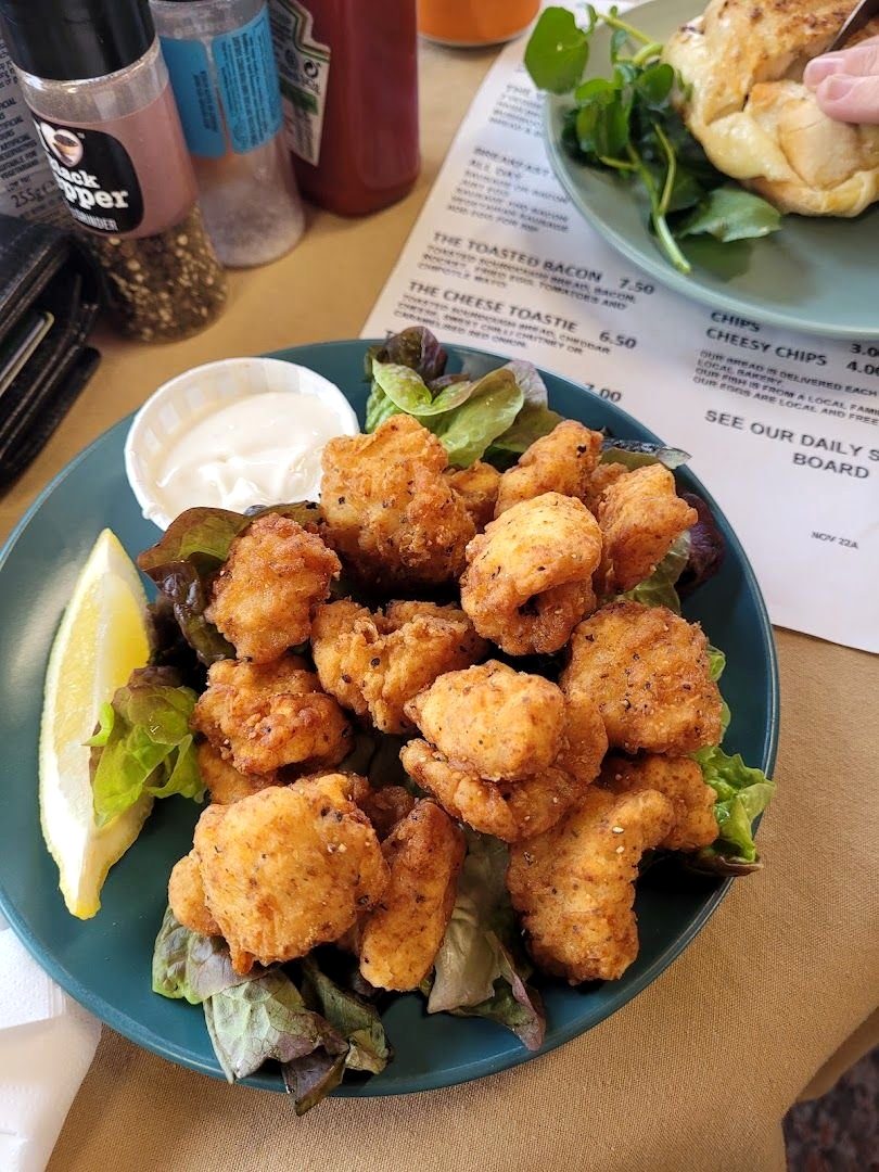 Breaded goujons with salad, a lemon wedge and a pot of tartare sauce